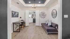 Un soggiorno moderno con zona pranzo, una cucina sullo sfondo e una parete grigia con un globo decorativo.