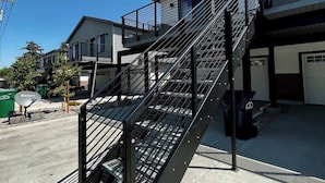 En moderne bygning med en metal trappe, der fører op til en balkon.
