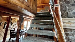 A wooden interior with a stone staircase leading to a higher level. - Timberline Cabin Near Bozeman! (Bozeman)