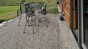A wooden cabin with a patio featuring a table and chairs, overlooking a green landscape. - Timberline Cabin Near Bozeman! (Bozeman)
