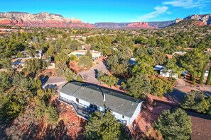 Surrounded by lush trees and a mountainous landscape, this house offers a serene retreat.