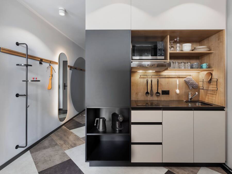 A modern kitchen with a microwave, stove, and various utensils.