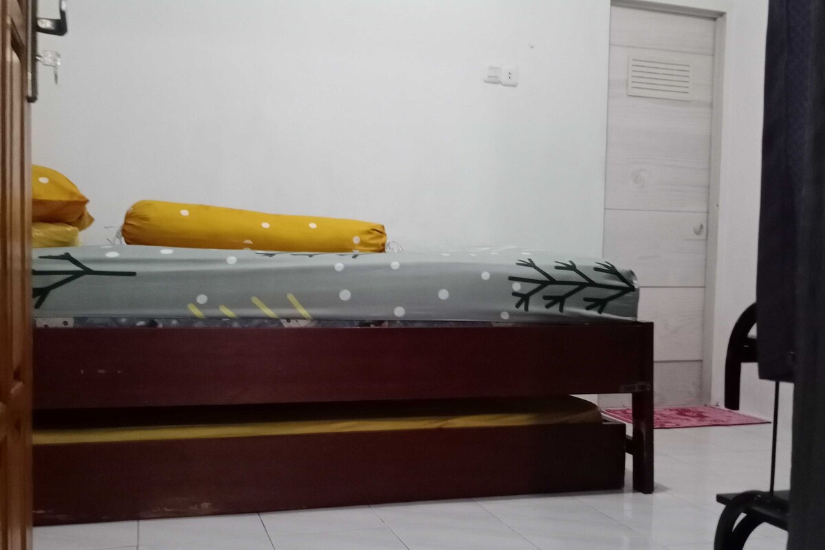 Une chambre à coucher avec un lit, une porte et une chaise.