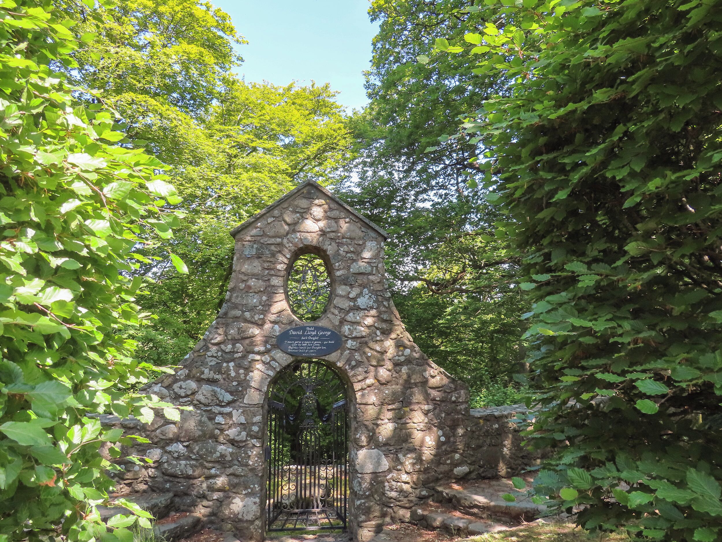 A stone structure with an archway and a plaque.