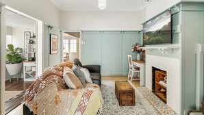 Un salon confortable avec un canapé, une cheminée et un téléviseur.