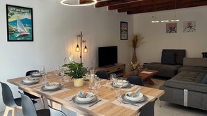 A dining area with a wooden table set for six, surrounded by black chairs. - Gîte Champfleury (Chindrieux)