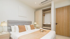 A neatly arranged bedroom with a bed, bedside tables, a wardrobe, and a hanging closet.