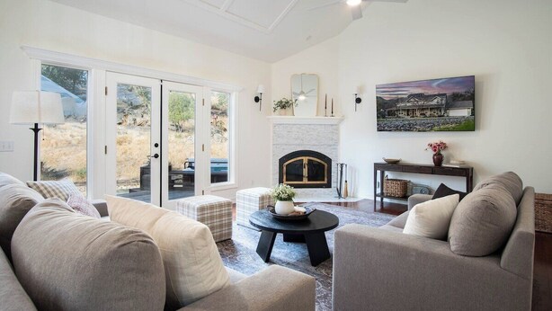 Una sala de estar con chimenea, un sofá, una mesa de centro y un cuadro en la pared.