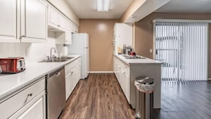 A modern kitchen with white cabinets, a stainless steel dishwasher, and a built-in oven. - Hoff Gardens 10 - 2BR 2BA - Downtown Lubbock (Lubbock)
