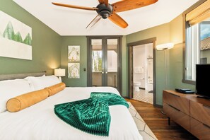 A hotel room with a bed, a ceiling fan, artwork on the walls, a window with a view, and a desk with a television. - Whiskey Ridge: 2 king suites, 1,848 sq ft, walk to gondola, garage elevator (Steamboat Springs)