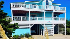 Un immeuble de deux étages doté d’un balcon et d’une enseigne sur laquelle on peut lire « Coral Escape ».