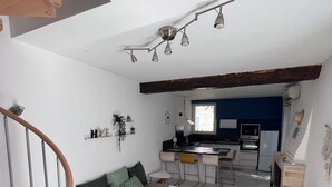 Ein moderner Wohnraum mit Treppe, einer Couch, einem Essbereich und einer Küche.