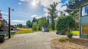 A residential driveway leading to a house with a garage, surrounded by trees and a clear sky. - Relax & Recharge: Edgewood Home w/ Balcony (Edgewood)