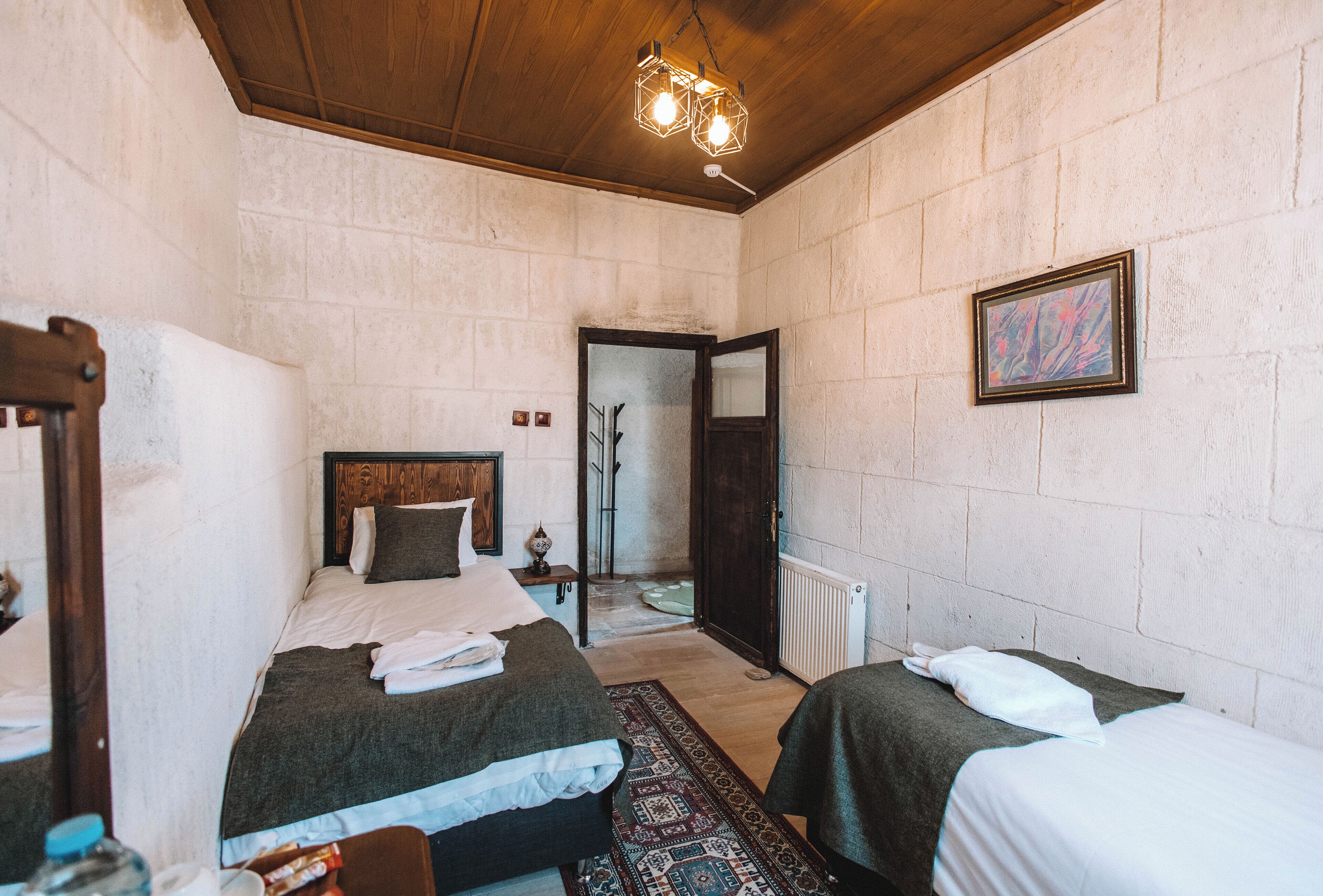 Habitación con dos camas, techo de madera y radiador.
