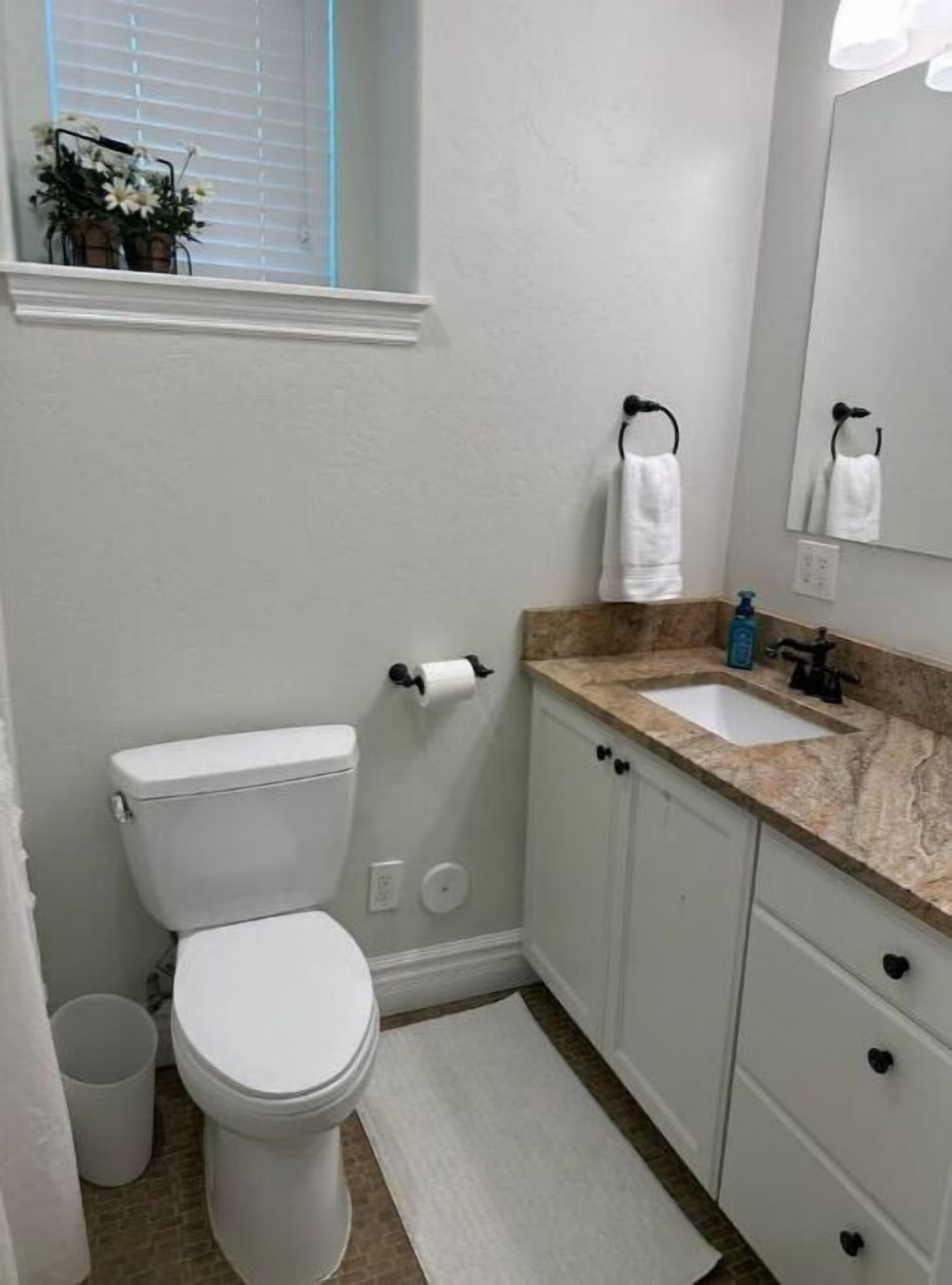 Un baño pequeño con inodoro, lavamanos y espejo.