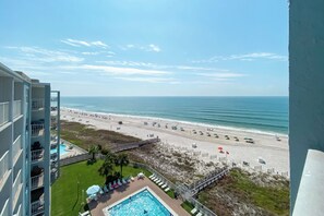 A high-rise hotel with a pool area, beach view, and a sandy beach with umbrellas. - Directly on the beach, SunSwept 808 (Orange Beach)