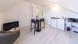 A compact, modern apartment with a kitchenette, a dining area, and a living space. - L'écrivain - Wifi - Saint-Serge (Angers)