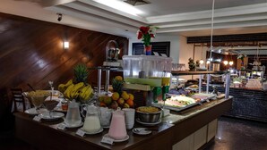 A buffet area with various food items and a fruit display. - Metropolitan Flats (Curitiba)