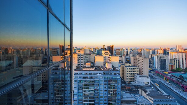 A high-rise building with multiple floors, large windows, and a cityscape view. - Metropolitan Flats (Curitiba)