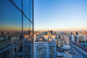A high-rise building with multiple floors, large windows, and a cityscape view. - Metropolitan Flats (Curitiba)