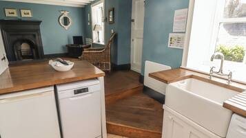 A kitchen with a dishwasher, a sink, and a window.
