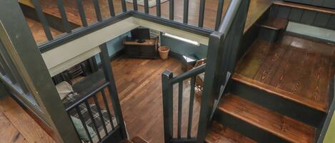 A wooden staircase with a black railing leading to a lower level.