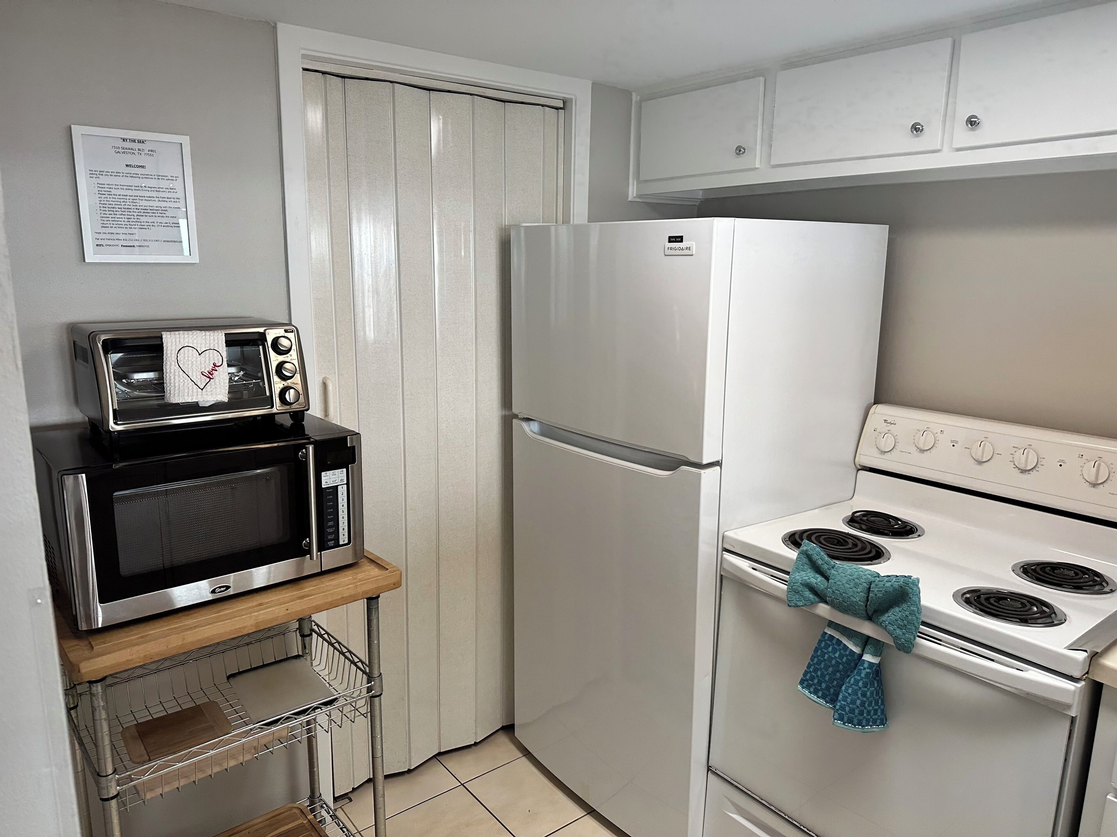 A compact kitchen with a microwave, refrigerator, and stove.