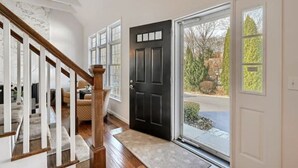 A staircase leading to a living area with a black door and a view of the outside. - Heated Indoor Pool and Spa - Golf Course View (Mashpee)