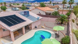 A residential area with a swimming pool, solar panels, and a view of mountains. - STOCKED Pool Home, RV & Boat parking, Game room. Sleeps 13 (Lake Havasu City)