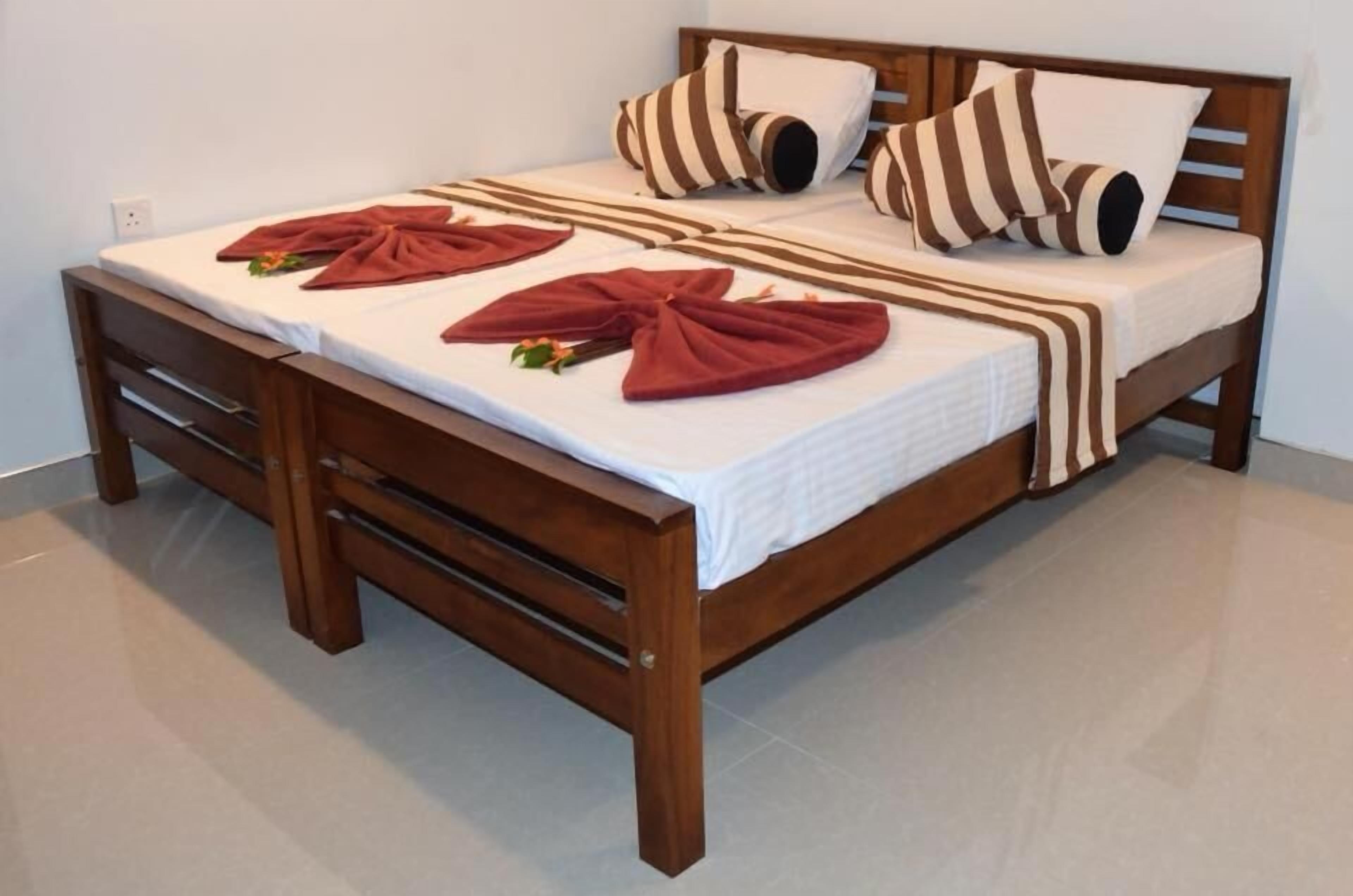 A neatly made bed with striped pillows and a wooden headboard.
