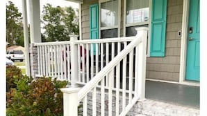 Une maison avec un porche, un escalier et une porte.