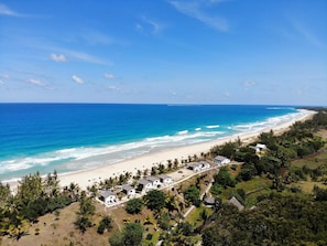 A coastal resort with beachfront villas, a sandy beach, and lush greenery. - Comfort Villa with Sea View (Sainte-Marie)