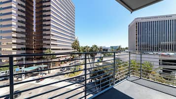 A view from a balcony overlooking a parking area with a building labeled "International City Bank" in the background.