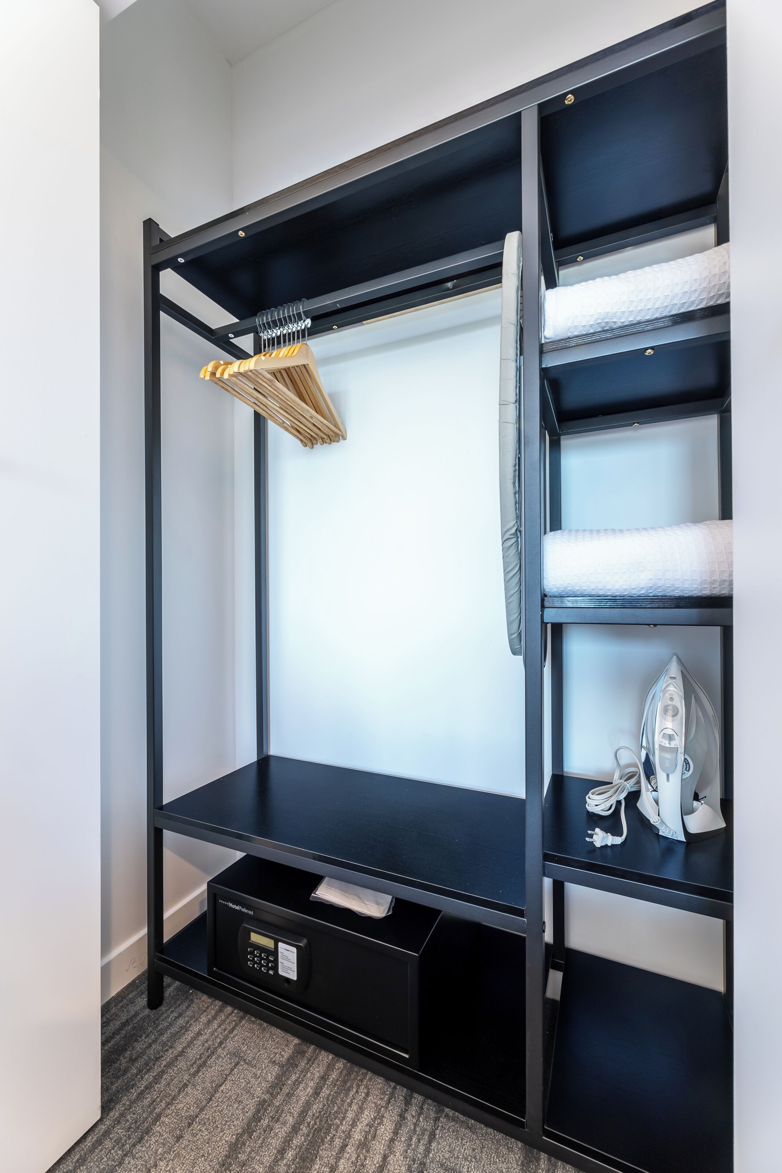 A black metal bunk bed with a built-in ironing board and storage drawers.