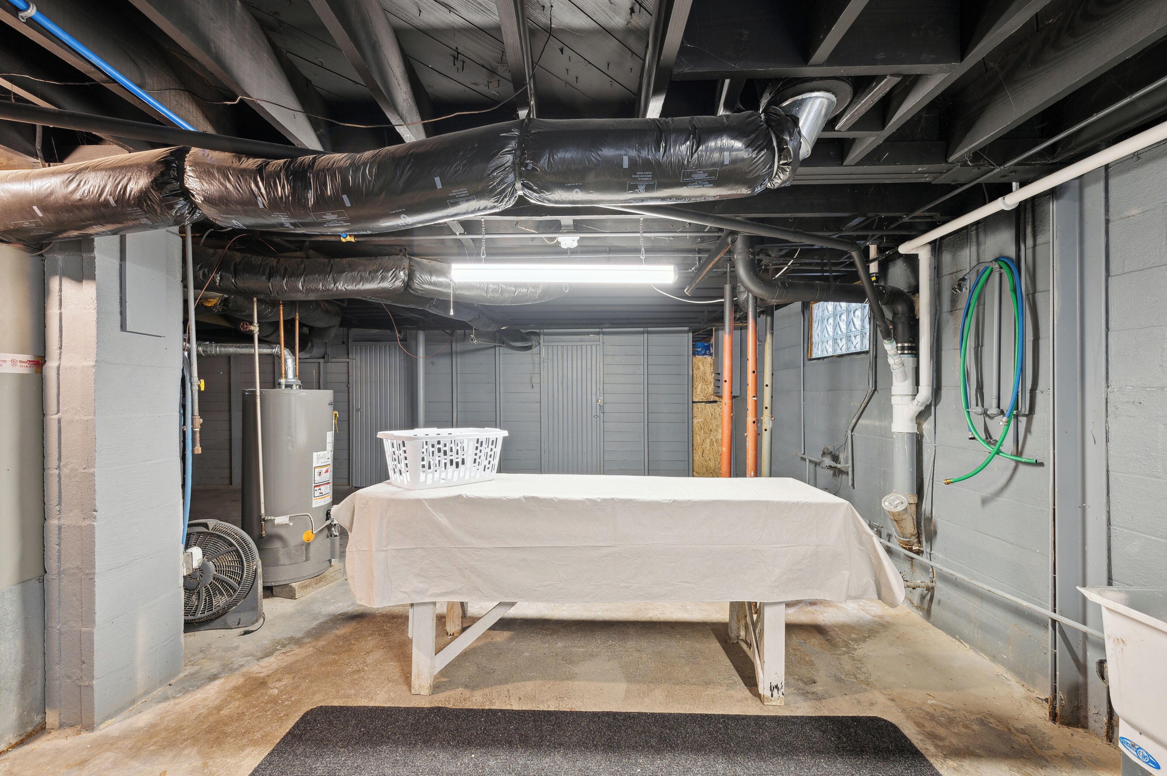 Een kamer met een bed, een verwarming en een ventilator.