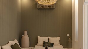 Una sala de estar moderna con una lámpara trenzada grande, un conjunto de sofá, una mesa de centro y un jarrón decorativo.