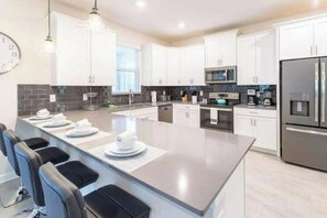 Enjoy cooking in this well-equipped kitchen with a central island and bar stools.