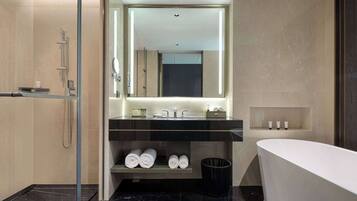 A modern bathroom with a glass-enclosed shower, a freestanding bathtub, and a vanity with a mirror and shelves for toiletries.