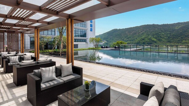 Une terrasse sur le toit avec des sièges extérieurs, une piscine et une vue sur un paysage montagneux.