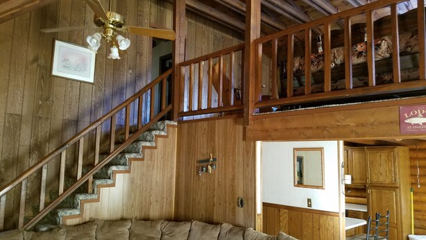 Un intérieur en bois avec un escalier, un canapé et un coin repas.