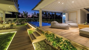 A modern outdoor living area with a pool, wooden deck, and seating. - 5-bdr luxury villa at a villa resort (Koh Samui)