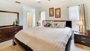 A bedroom with a bed, a ceiling fan, a dresser, a nightstand, and a window with blinds. - Winter Haven Retreat w/ Private Pool! (Winter Haven)