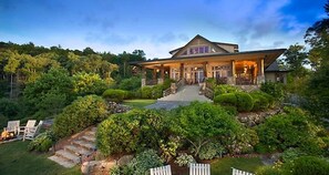 A large, two-story house with a prominent front porch and a stone staircase leading to the entrance.