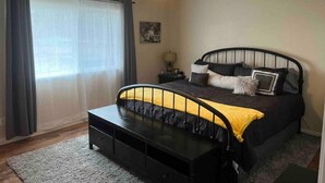 A bedroom with a bed, bedside tables, a ceiling fan, and a window with curtains. - HUGE house across st from GC railway- hot tub (Williams)