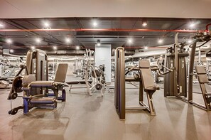 A gym with various exercise machines, including weight benches and free weights.