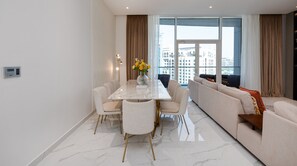 Ein modernes Wohnzimmer mit Essbereich, großen Fenstern und Blick auf die Stadt.