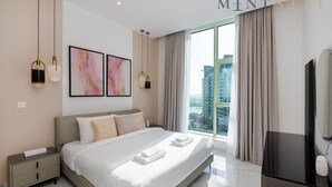 Een moderne hotelkamer met een groot bed, nachtkastjes, een flatscreen-televisie en uitzicht over de stad.
