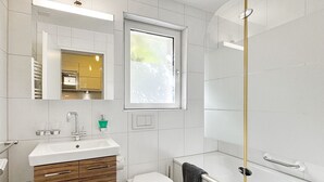 A modern bathroom with a white sink, wooden vanity, a toilet, and a bathtub. - Studio Marmotta - Zermatt (Zermatt)