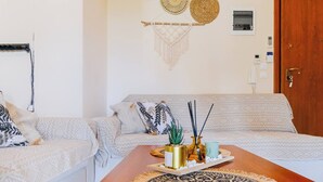 Ein gemütliches Wohnzimmer mit einem Holztisch, gemusterten Kissen und dekorativen Wandbehängen.