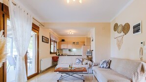 Ein gemütliches Wohnzimmer mit einer Couch, einem Couchtisch und Blick auf die Küche.
